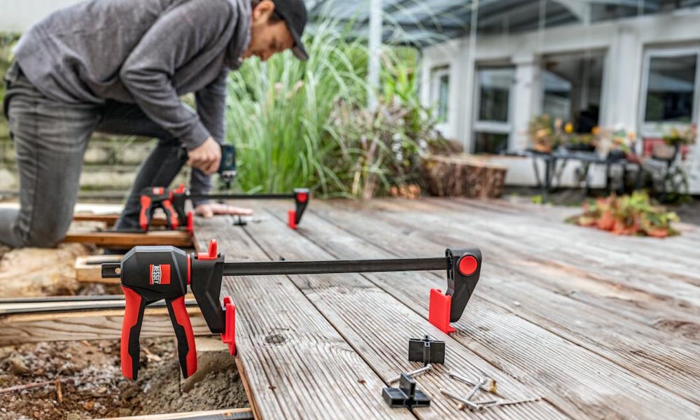 Bessey Einhandzwinge bei der Verlegung von Terrassendielen im Außenbereich